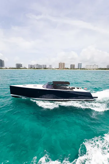 M/y 55 Van Dutch Yacht Photos Pics 2017 VanDutch 55 yacht cruising on turquoise waters near a city skyline.