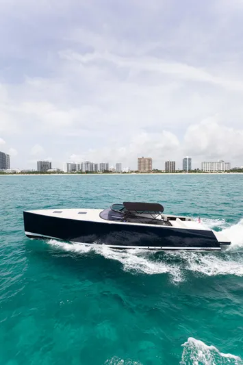 M/y 55 Van Dutch Yacht Photos Pics 2017 VanDutch 55 yacht cruising on turquoise waters near a city skyline.