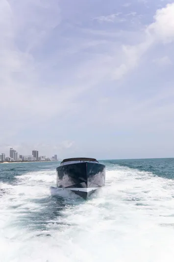 M/y 55 Van Dutch Yacht Photos Pics VanDutch 55 yacht cruising on open sea, 2017 model, with city skyline in background.