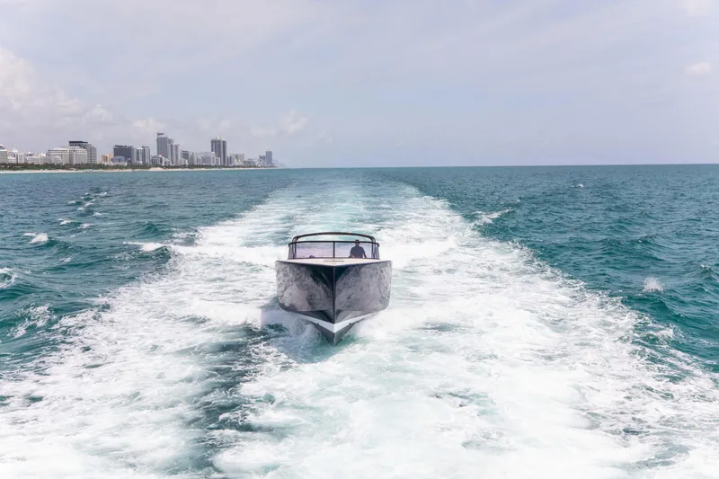 M/y 55 Van Dutch Yacht Photos Pics VanDutch 55 yacht cruising on open sea, 2017 model, with city skyline in background.