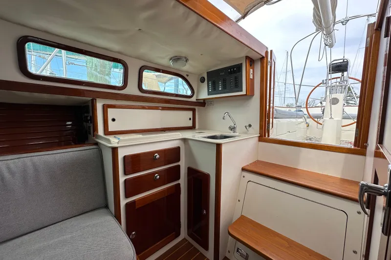 Ibis Yacht Photos Pics Interior of a 2006 Morris M36 sailboat with wooden cabinetry and compact kitchen area.