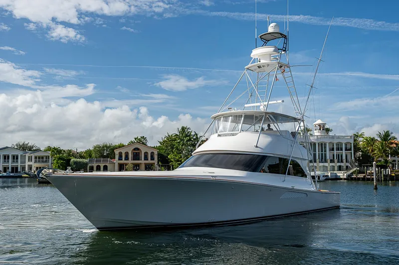 Big Blue Yacht Photos Pics 2007 Viking 64 Convertible yacht on calm water, with luxury homes in the background.