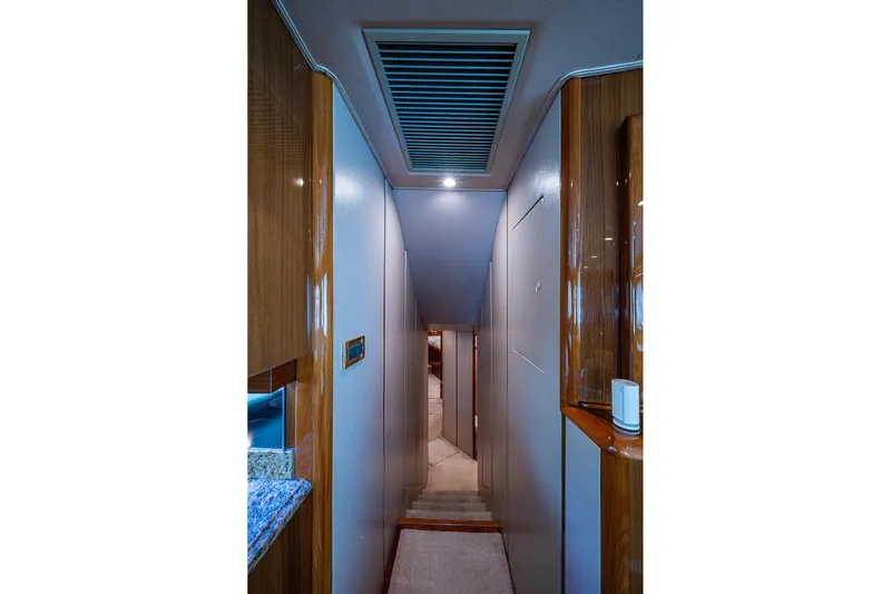 Big Blue Yacht Photos Pics Narrow hallway inside 2007 Viking 64 Convertible yacht with wood accents and modern lighting.