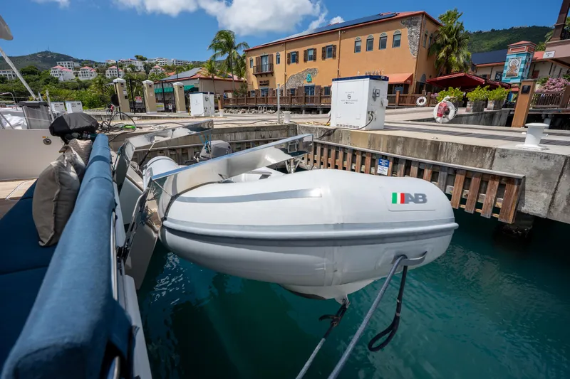  Yacht Photos Pics Docked Fountaine Pajot SABA 50 catamaran with inflatable dinghy, 2020 model, in a scenic marina.