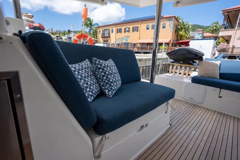  Yacht Photos Pics Luxury seating on 2020 Fountaine Pajot SABA 50 yacht, docked with scenic marina view.