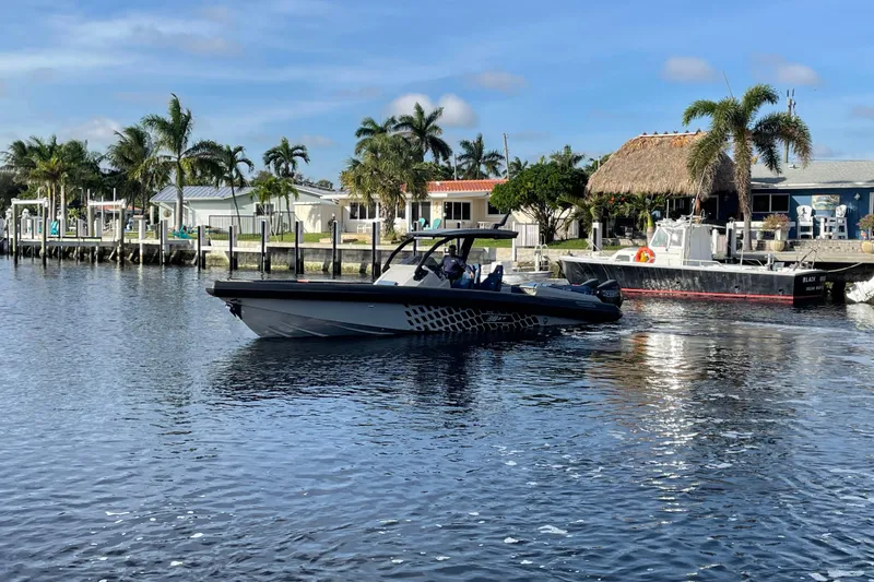  Yacht Photos Pics 2023 Skipper-BSK BSK 38 boat cruising on a sunny waterfront with palm trees.