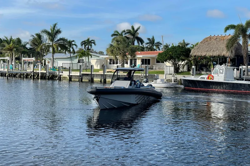  Yacht Photos Pics 2023 Skipper-BSK BSK 38 boat cruising near a tropical waterfront with palm trees.