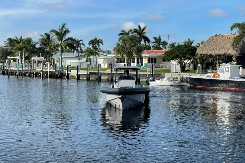  Yacht Photos Pics 2023 Skipper-BSK BSK 38 boat cruising near waterfront homes and palm trees.