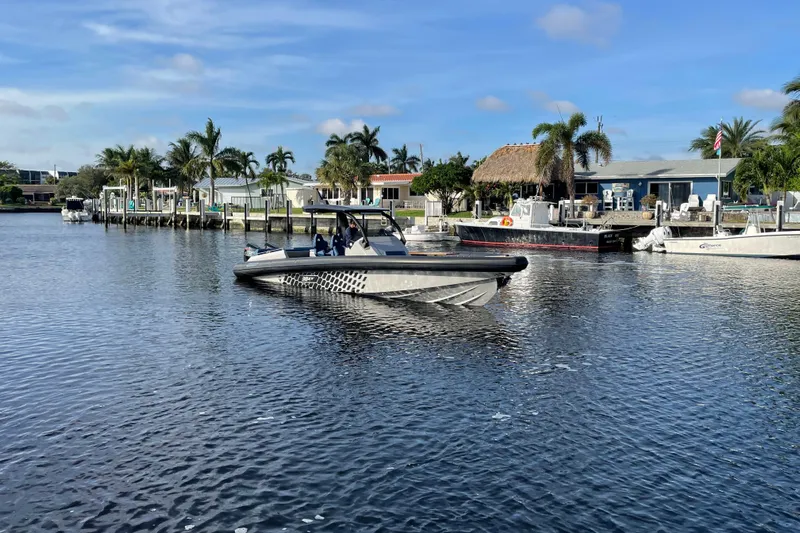  Yacht Photos Pics 2023 Skipper-BSK BSK 38 boat cruising in a scenic waterfront area with palm trees.