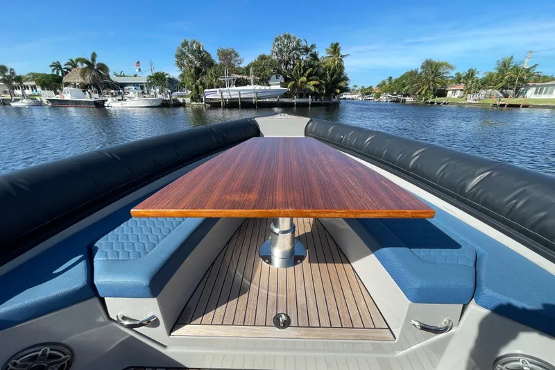  Yacht Photos Pics Luxurious 2023 Skipper-BSK BSK 38 boat interior with wooden table and blue seating.