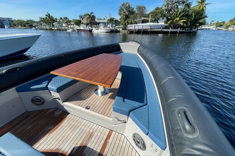  Yacht Photos Pics 2023 Skipper-BSK BSK 38 boat with wooden table and blue seating on calm water.