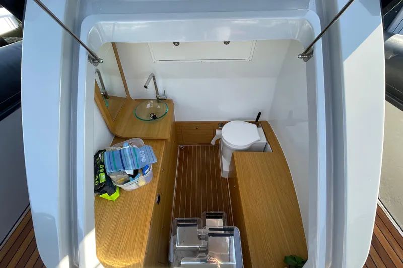  Yacht Photos Pics 2023 Skipper-BSK BSK 38 boat interior with wooden flooring and compact bathroom amenities.