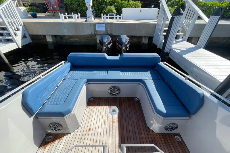  Yacht Photos Pics Luxurious seating area on 2023 Skipper-BSK BSK 38 boat with blue cushions and wooden deck.