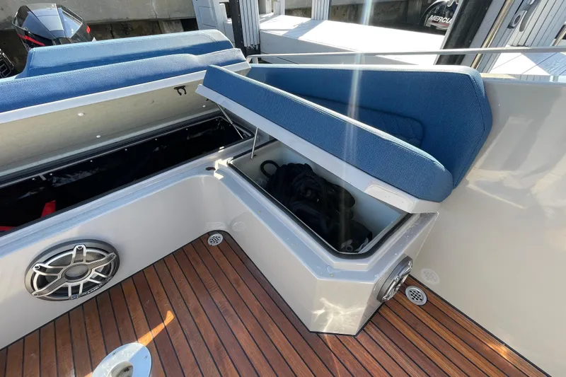  Yacht Photos Pics 2023 Skipper-BSK BSK 38 boat interior with open storage compartment and blue seating.