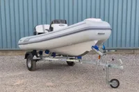 2024 AB Inflatables 10 ALX boat on trailer, parked on gravel.