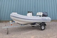 2024 AB Inflatables 10 ALX boat on trailer, parked on gravel.