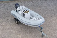 2024 AB Inflatables 10 ALX boat on trailer, gray with outboard motor.