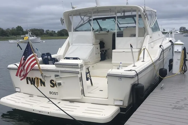  Yacht Photos Pics 1998 Tiara Yachts 3700 Open docked, featuring spacious deck and American flag.