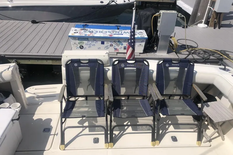  Yacht Photos Pics 1998 Tiara Yachts 3700 Open with three chairs on deck, dockside view.