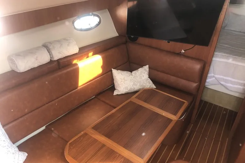  Yacht Photos Pics 1998 Tiara Yachts 3700 Open interior with leather seating, wooden table, and mounted TV.