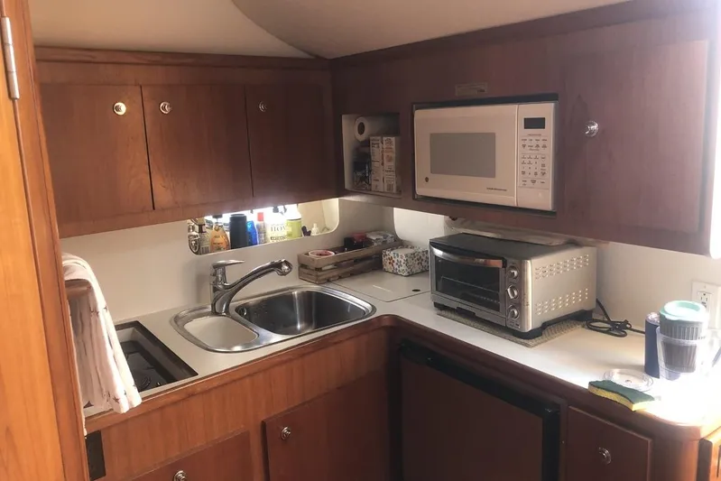  Yacht Photos Pics Compact kitchen in 1998 Tiara Yachts 3700 Open, featuring microwave, sink, and toaster oven.