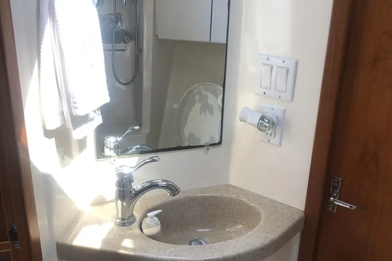  Yacht Photos Pics Bathroom sink area in a 1998 Tiara Yachts 3700 Open, featuring a mirror and faucet.