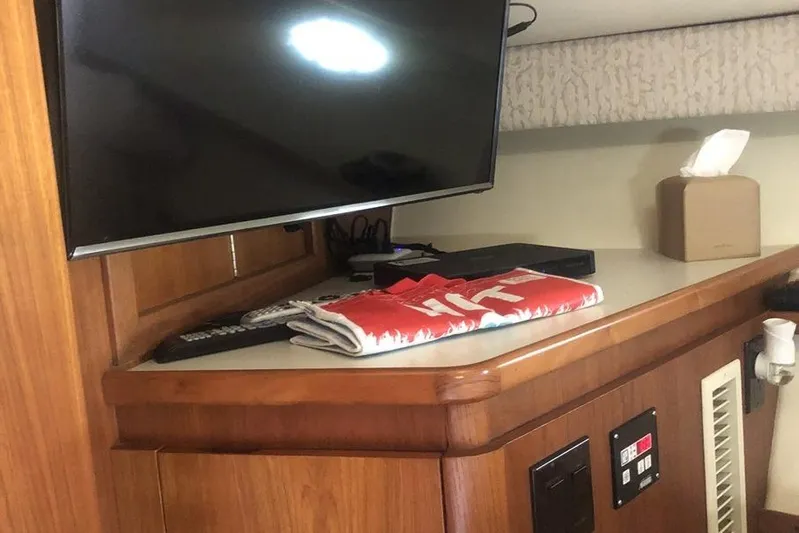  Yacht Photos Pics 1998 Tiara Yachts 3700 Open interior with TV, remote, and tissue box on wooden counter.
