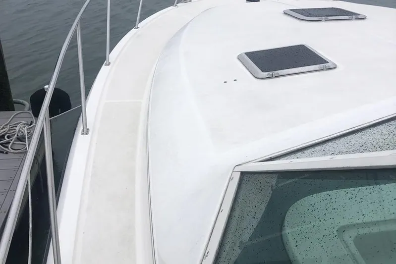  Yacht Photos Pics 1998 Tiara Yachts 3700 Open boat deck with railing and hatches, docked by water.