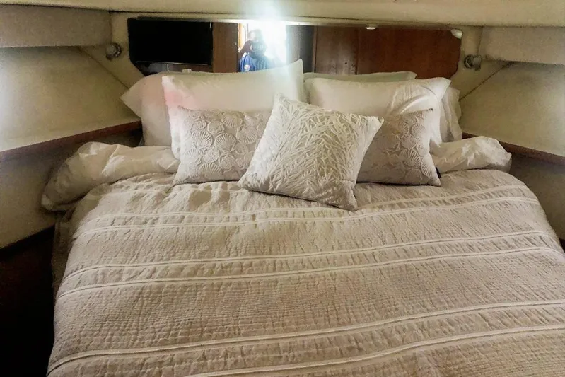  Yacht Photos Pics Cozy cabin bedroom in 1998 Tiara Yachts 3700 Open, featuring elegant bedding and pillows.