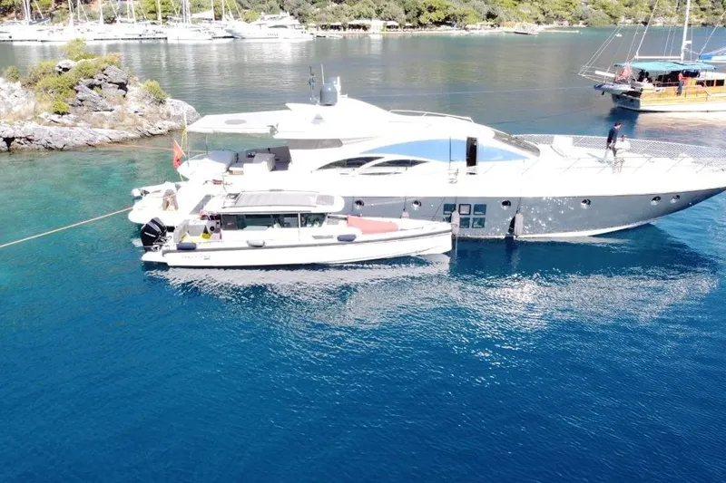  Yacht Photos Pics 2007 Azimut 86S yacht anchored in clear blue water, with smaller boat alongside.