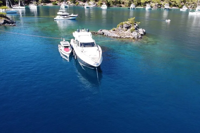  Yacht Photos Pics Azimut 86S yacht anchored in a serene bay, surrounded by clear blue water.