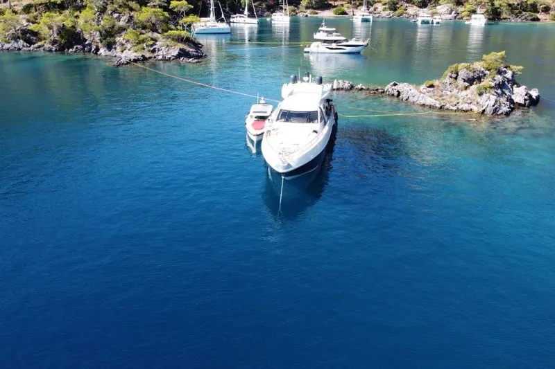  Yacht Photos Pics 2007 Azimut 86S yacht anchored in a serene, turquoise bay with lush surroundings.