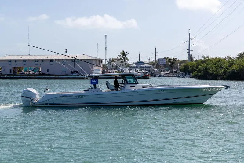  Yacht Photos Pics 2019 HCB 53 Sueños boat cruising in a marina under a clear sky.