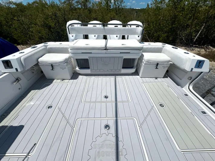  Yacht Photos Pics 2019 HCB 53 Sueños boat deck with seating and storage, surrounded by lush greenery.