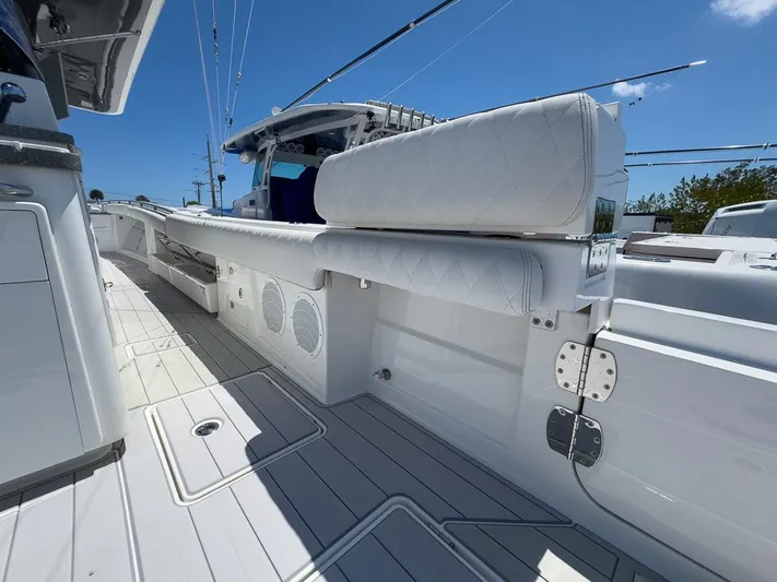  Yacht Photos Pics 2019 HCB 53 Sueños boat deck with white seating and speakers under a clear blue sky.