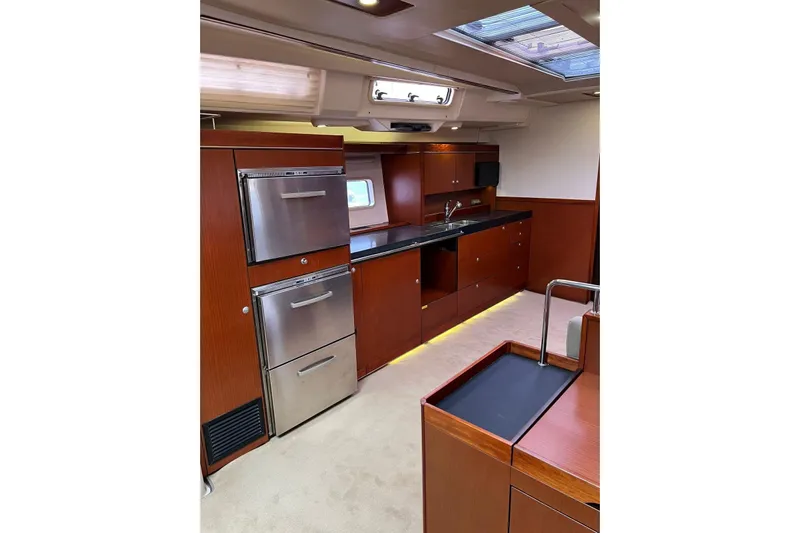  Yacht Photos Pics Luxurious interior of 2013 Hanse 575 yacht with modern kitchen and sleek wood finish.