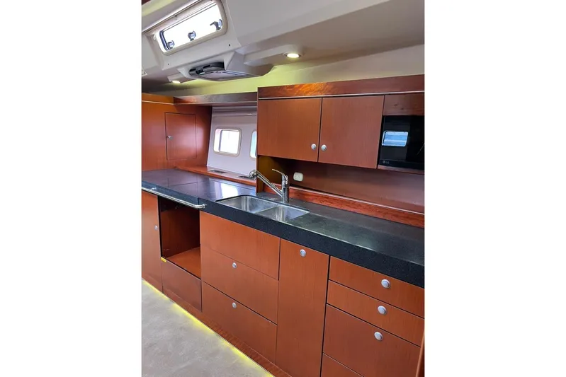  Yacht Photos Pics Modern kitchen interior of 2013 Hanse 575 yacht with wooden cabinets and sleek countertops.