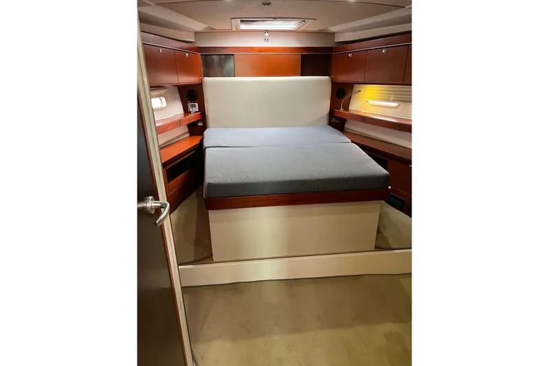  Yacht Photos Pics Luxurious cabin interior of 2013 Hanse 575 yacht with cozy bed and wooden accents.