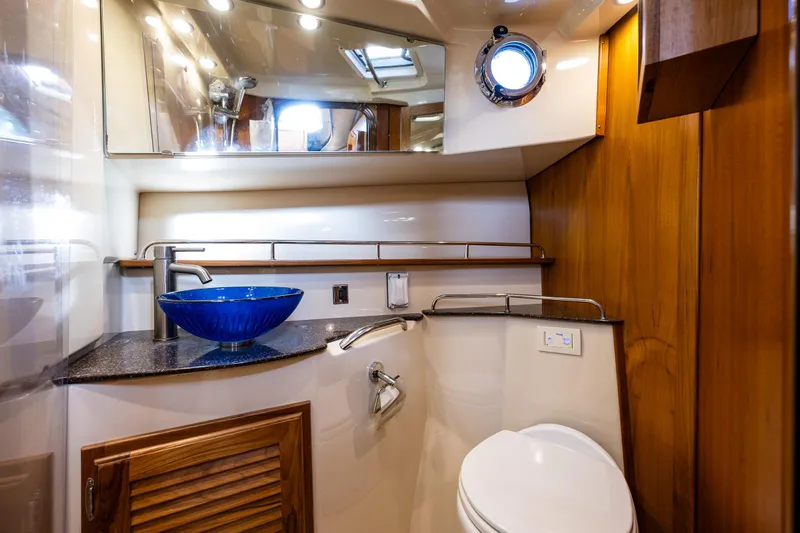 Toujours Yacht Photos Pics Luxurious bathroom in 2021 Ranger Tugs R-31 CB with modern fixtures and blue glass sink.