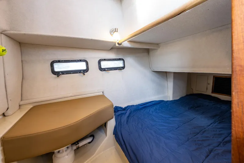 Toujours Yacht Photos Pics 2021 Ranger Tugs R-31 CB cabin interior with cozy bed and porthole windows.