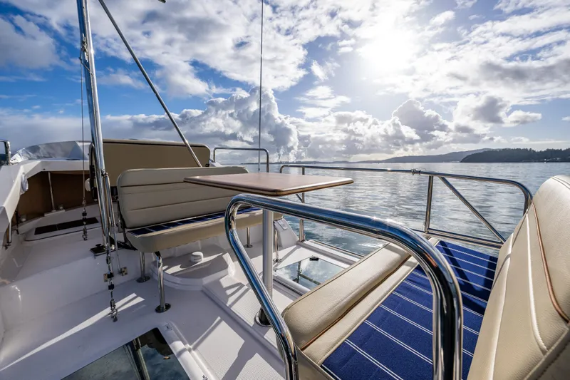 Toujours Yacht Photos Pics 2021 Ranger Tugs R-31 CB boat deck with seating, under a bright sky.