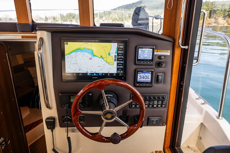 Toujours Yacht Photos Pics 2021 Ranger Tugs R-31 CB helm with navigation display and wooden steering wheel.