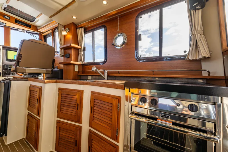 Toujours Yacht Photos Pics Interior of 2021 Ranger Tugs R-31 CB with wood cabinetry and stainless steel appliances.