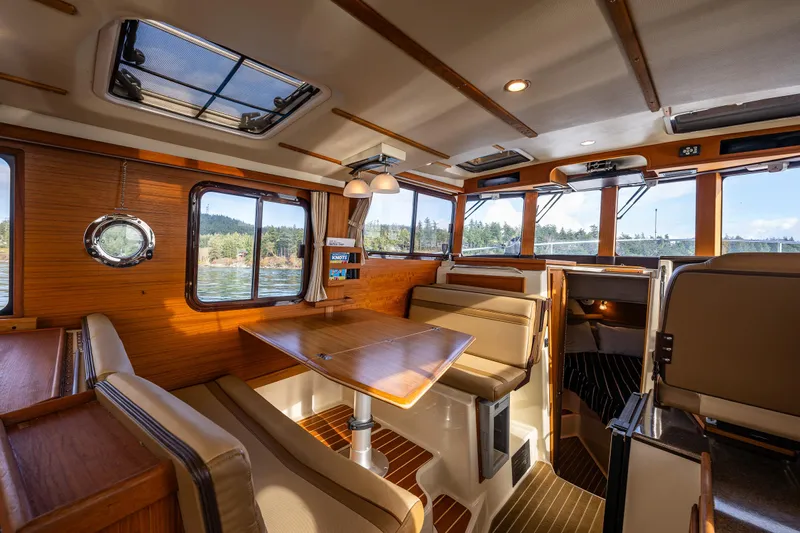 Toujours Yacht Photos Pics Interior of 2021 Ranger Tugs R-31 CB, featuring elegant wood finishes and spacious seating.