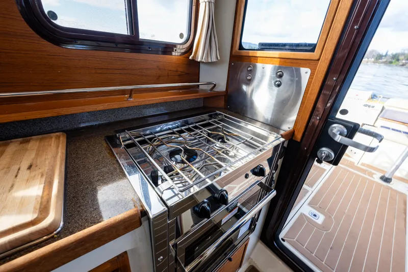 Toujours Yacht Photos Pics 2021 Ranger Tugs R-31 CB interior kitchen with stove and wooden accents.