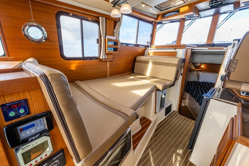 Toujours Yacht Photos Pics Interior of 2021 Ranger Tugs R-31 CB, featuring cozy seating and wood accents.