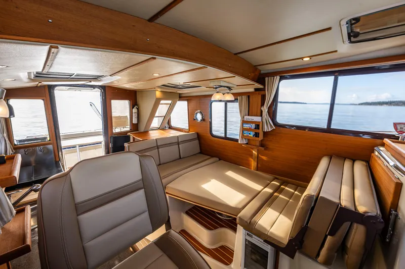 Toujours Yacht Photos Pics Interior of 2021 Ranger Tugs R-31 CB boat, featuring cozy seating and large windows.