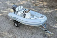 2022 AB Inflatables 9.5 Alx boat on trailer, parked on gravel surface.
