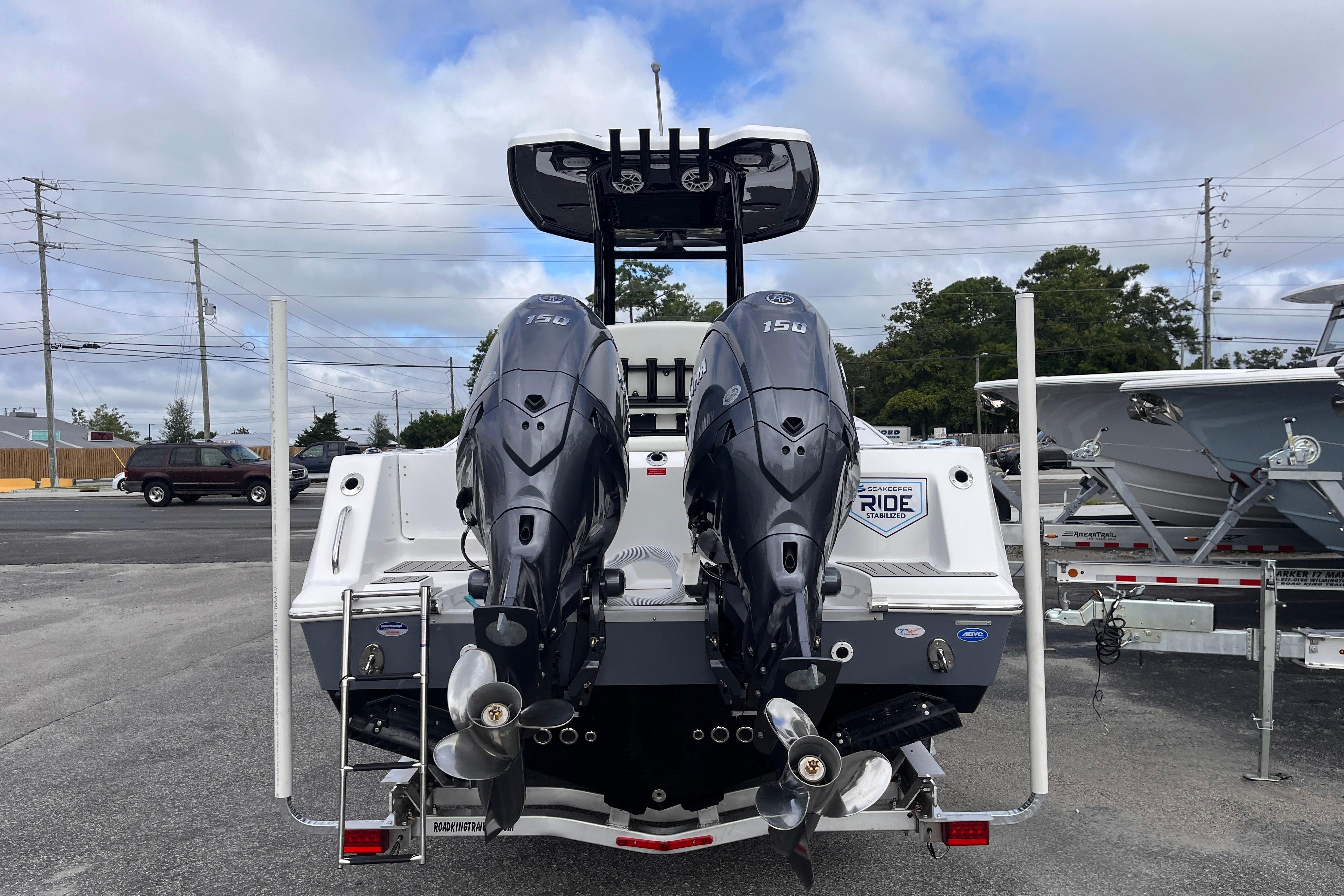 2026 Tidewater 256 CC Adventure boat with dual outboard engines, parked on a trailer.