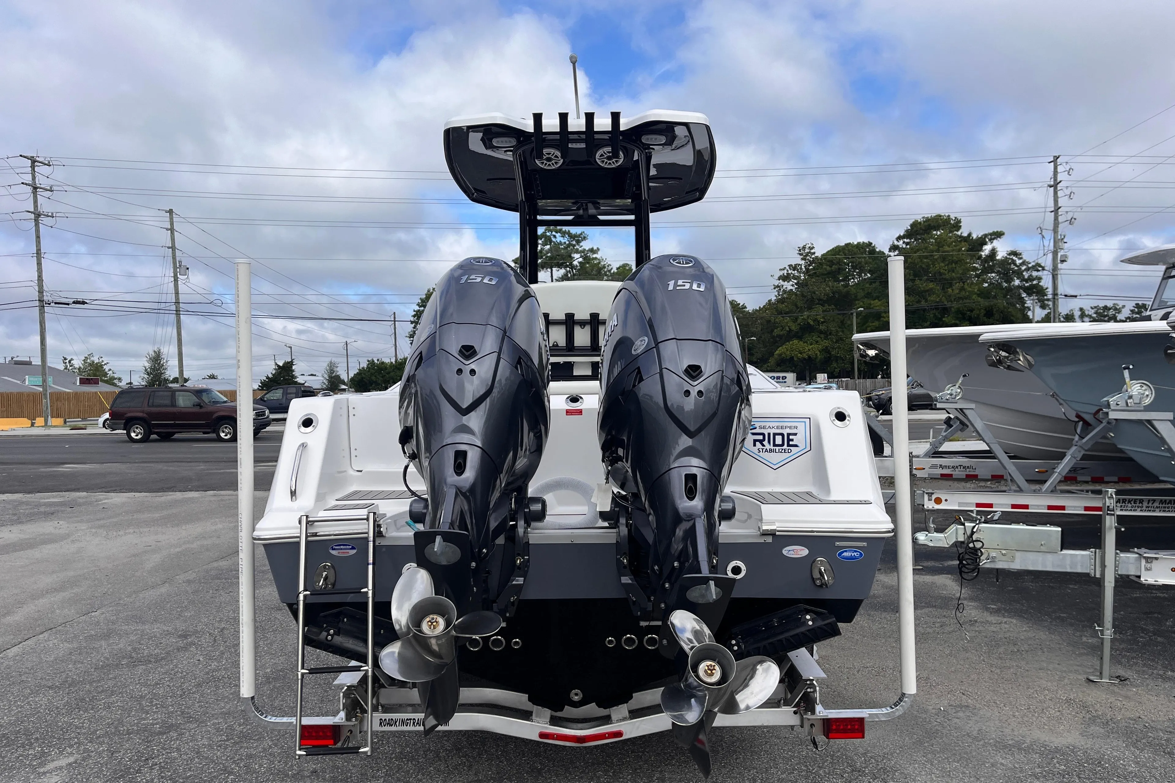 2026 Tidewater 256 CC Adventure boat with dual outboard engines, parked on a trailer.
